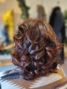 Cheveux courts bouclés brun auburn, vue de dos